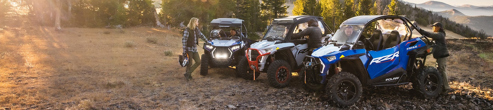 People getting ready to ride Polaris vehicles